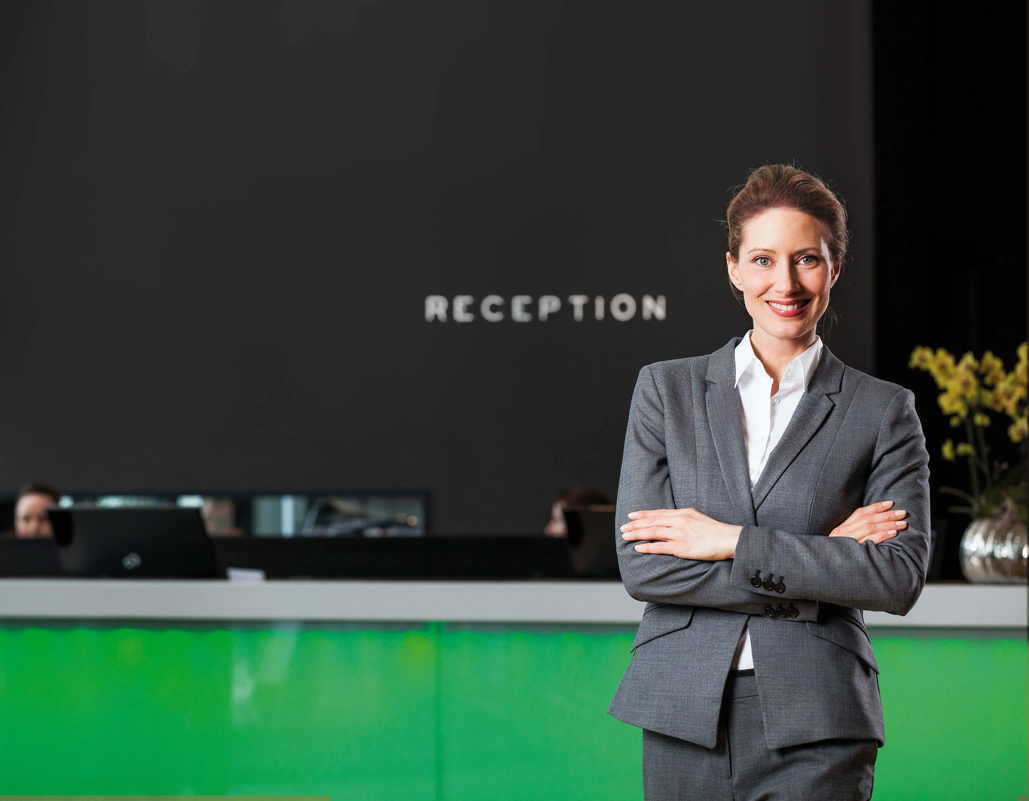 Rezeptionistin lächelt in Kamera