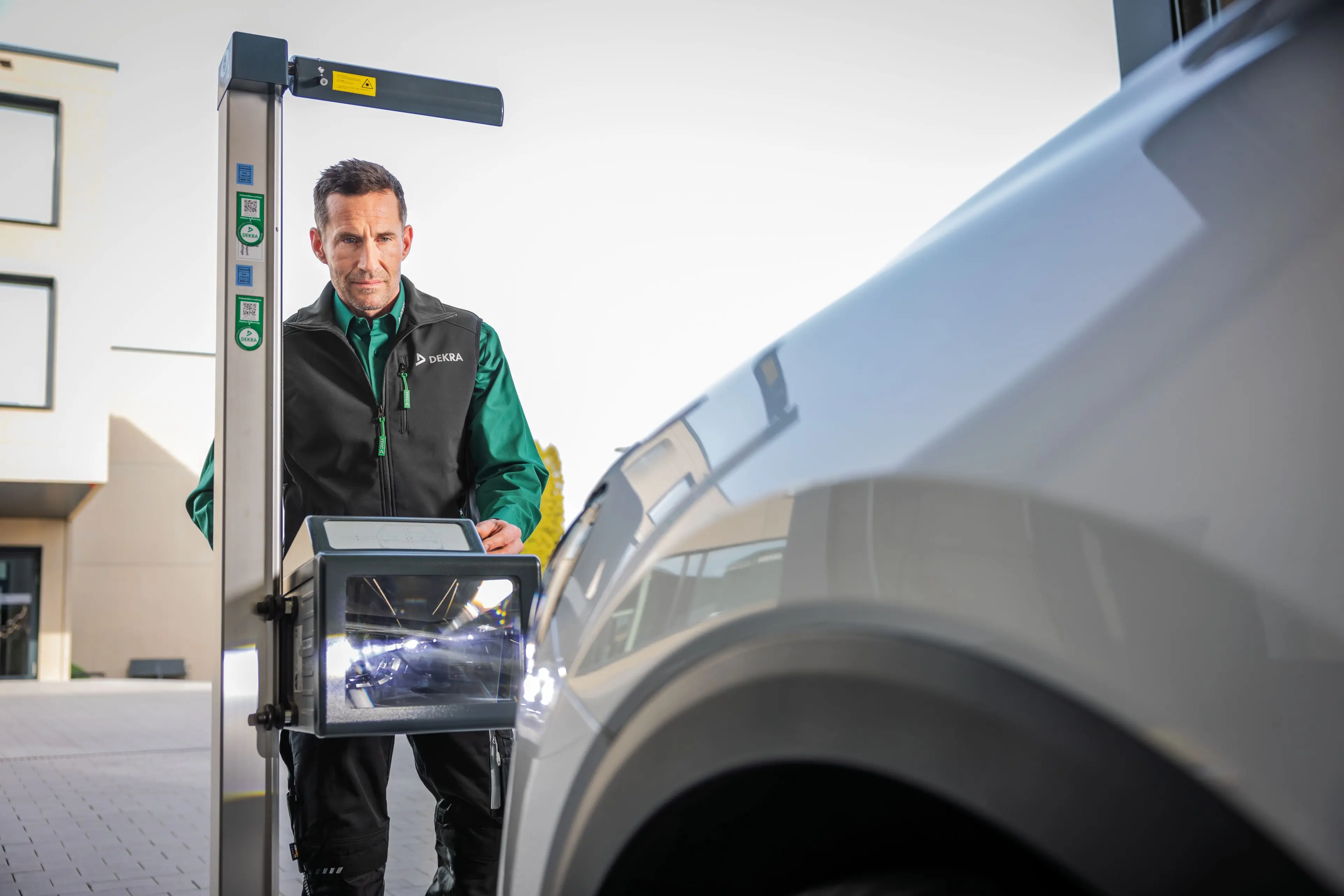 DEKRA Prüfer begutachtet Auto bei der Hauptuntersuchung