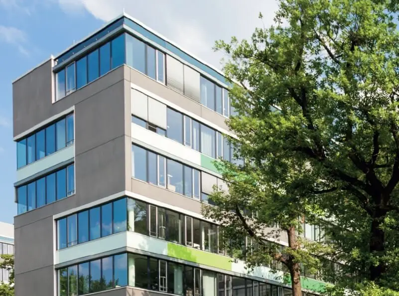 Bürogebäudeteil mit Baum davor 