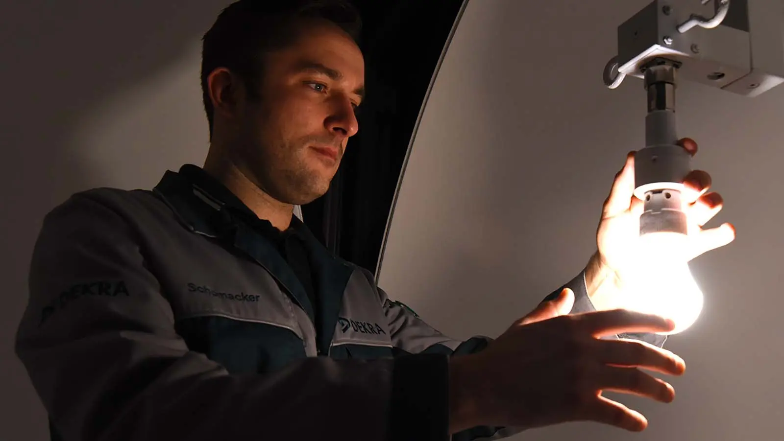 Mann hält Hände an eine Glühbirne 