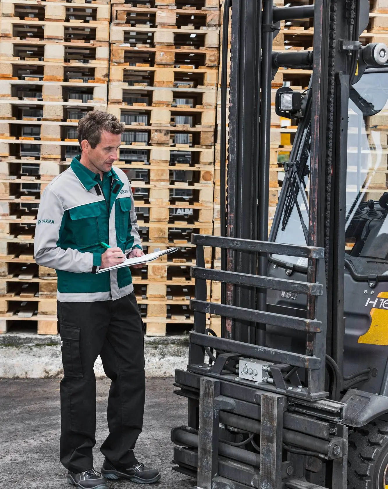 DEKRA Sachverständiger mit Klemmbrett neben einem Gabelstapler
