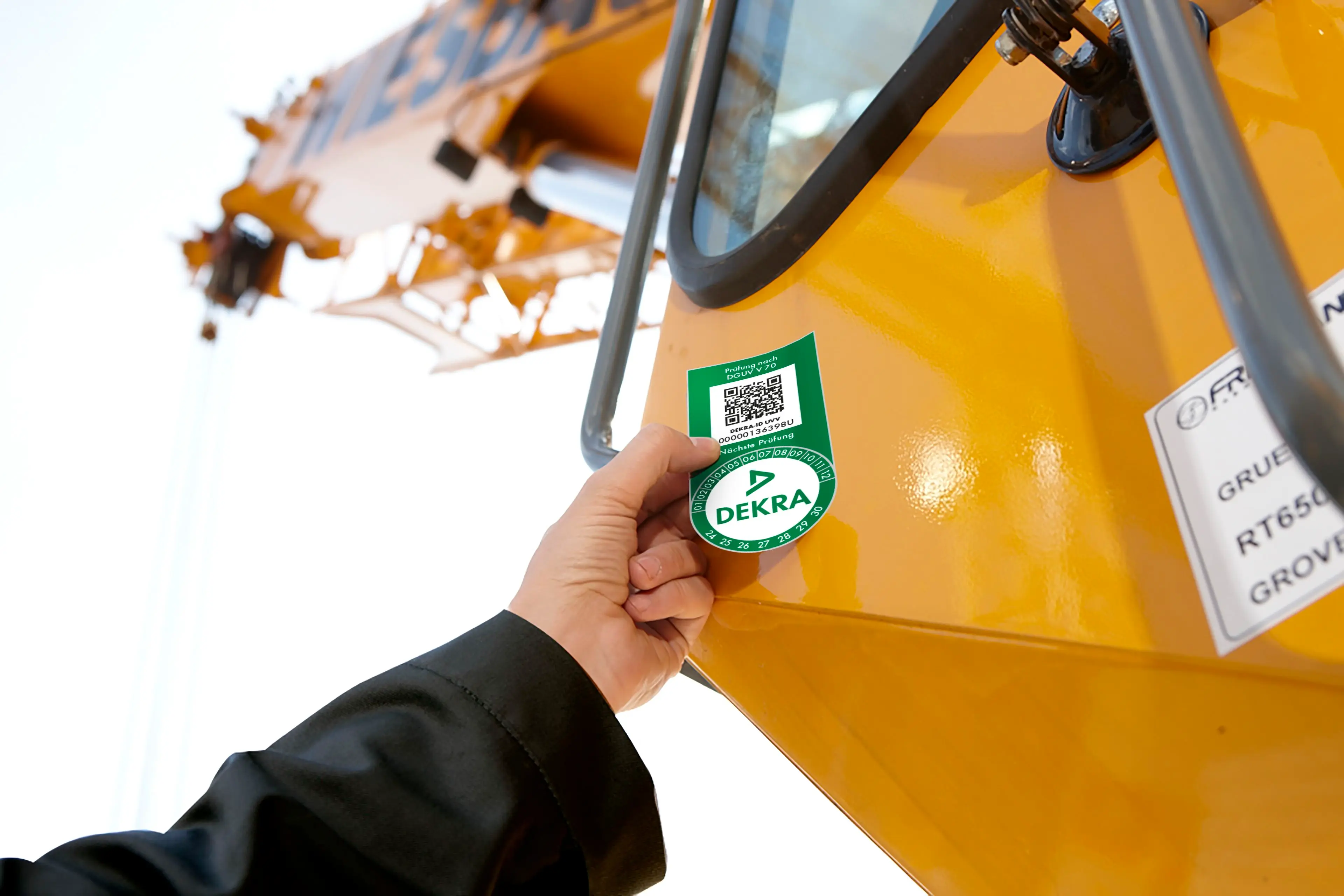 Das DEKRA Prüfsiegel wird am Baukran aufgebracht