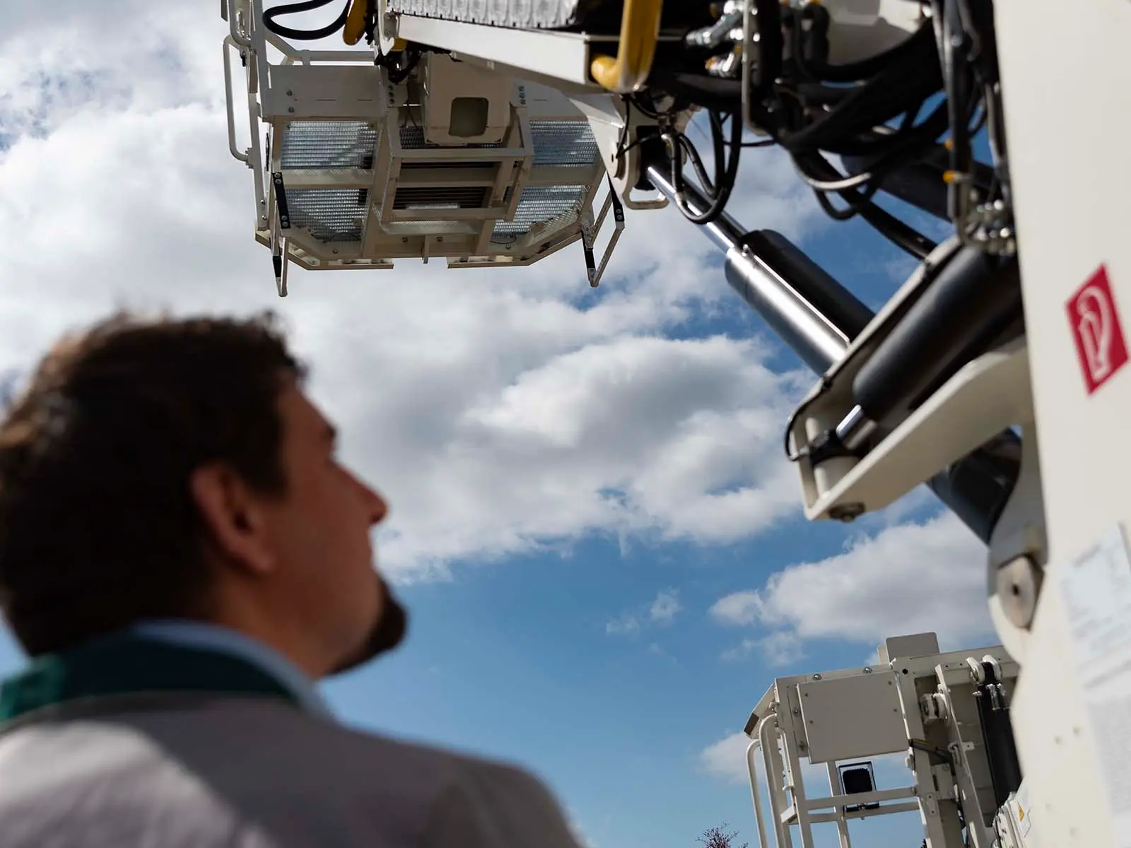 Mann unter Hebemaschine 