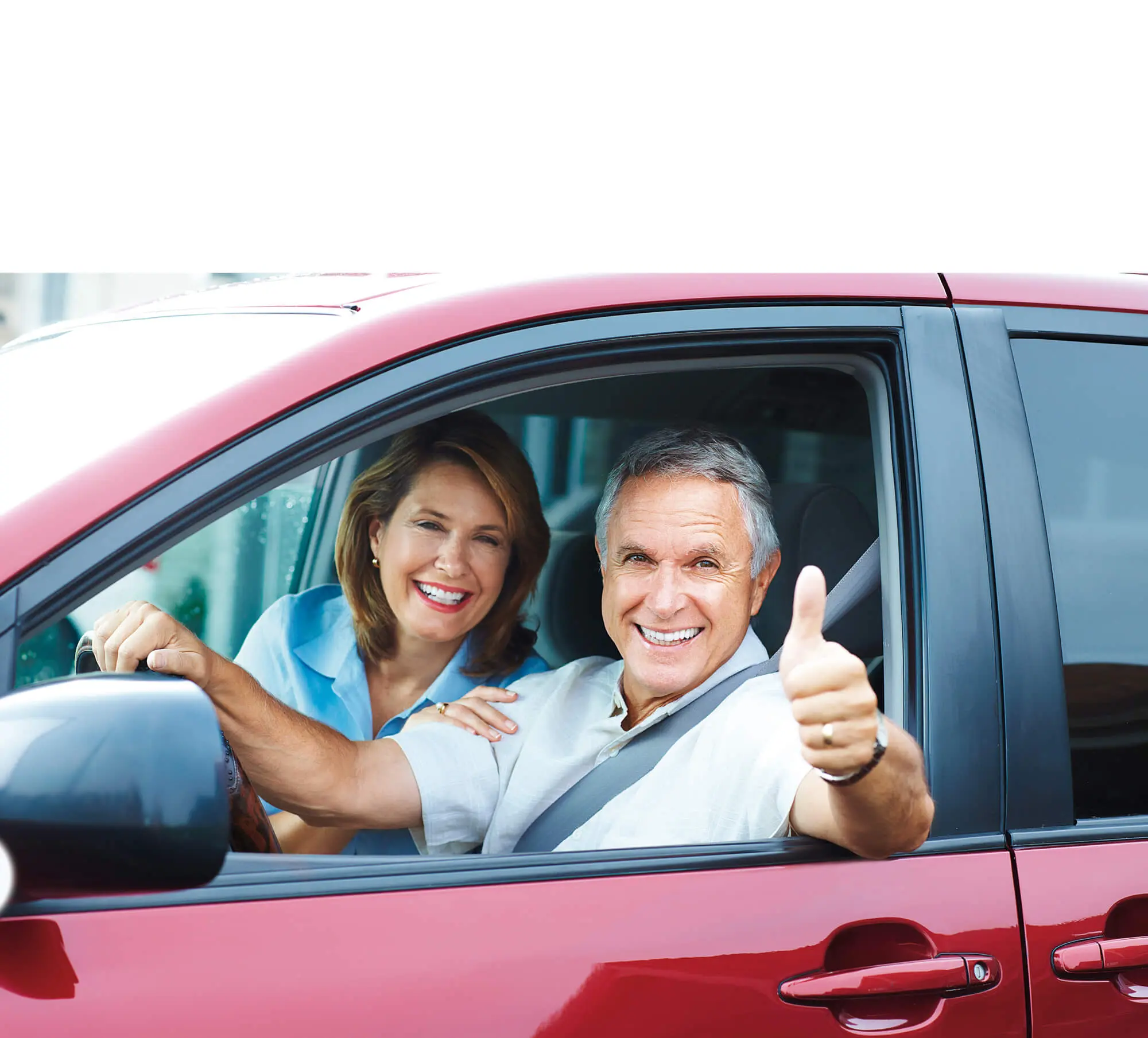Zwei ältere Personen schauen lächelnd aus einem Auto Zwei ältere Personen schauen lächelnd aus einem Auto