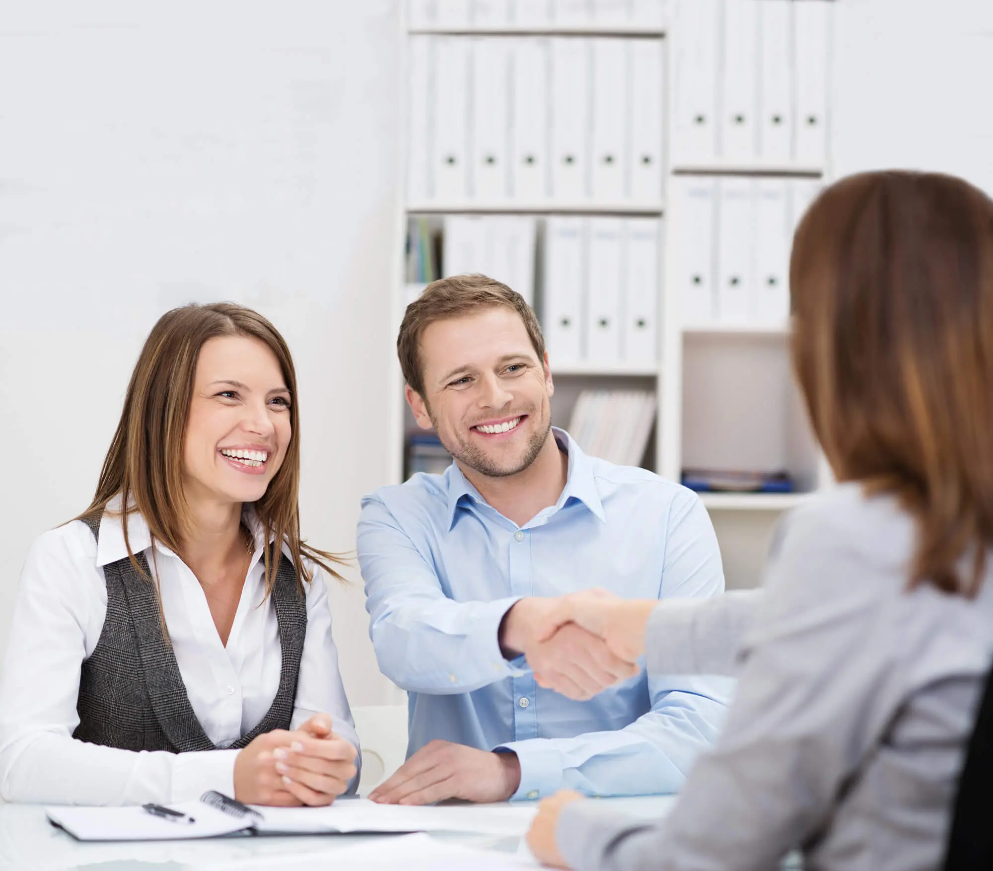 DEKRA Expertin schüttelt zufriedenem Kunden die Hand