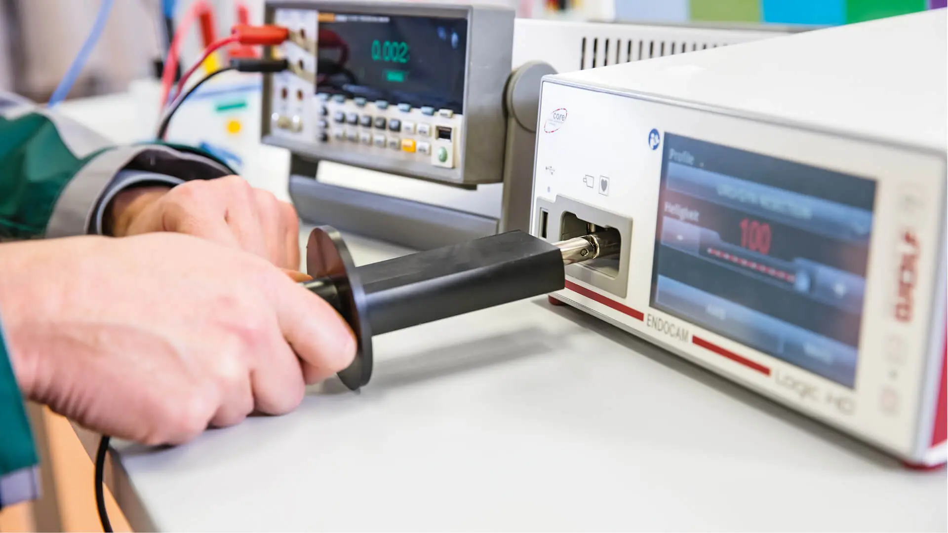 DEKRA Mitarbeitender prüft mit Messsonde ein elektrisches Messgerät im Laborumfeld