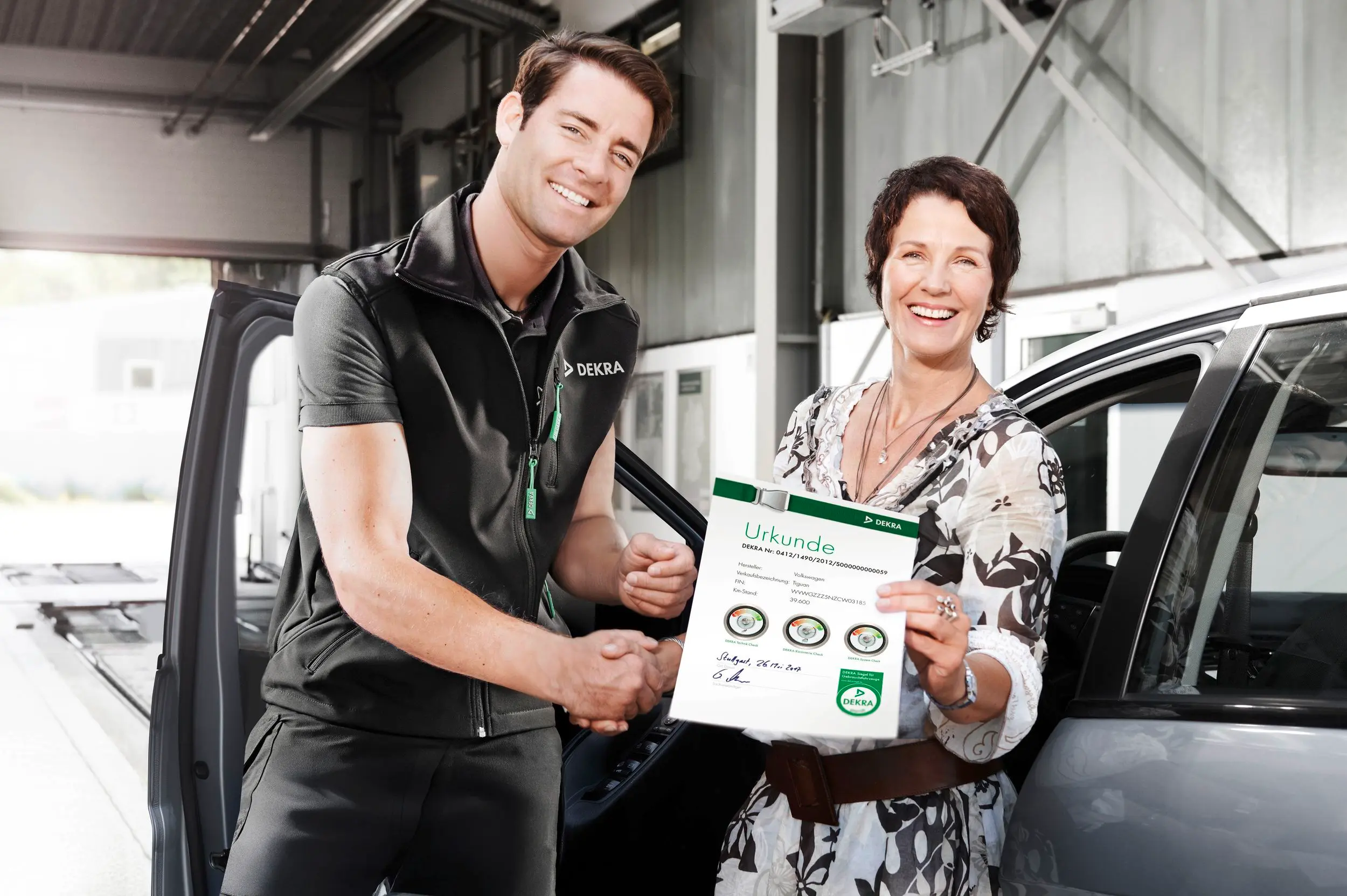 DEKRA Prüfer übergibt Kunding DEKRA Gebrauchtwagen Siegel