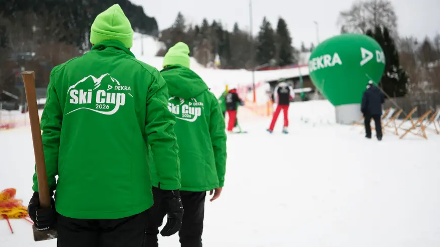 Mitarbeiter in grüner Skikleidung beim DEKRA Skirennen