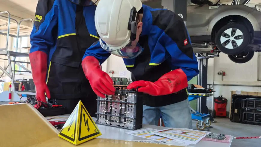 Teilnehmer der DEKRA Hochvoltschulung in Duisburg arbeiten mit Schutzausrüstung an einer Hochvolt-Batterie