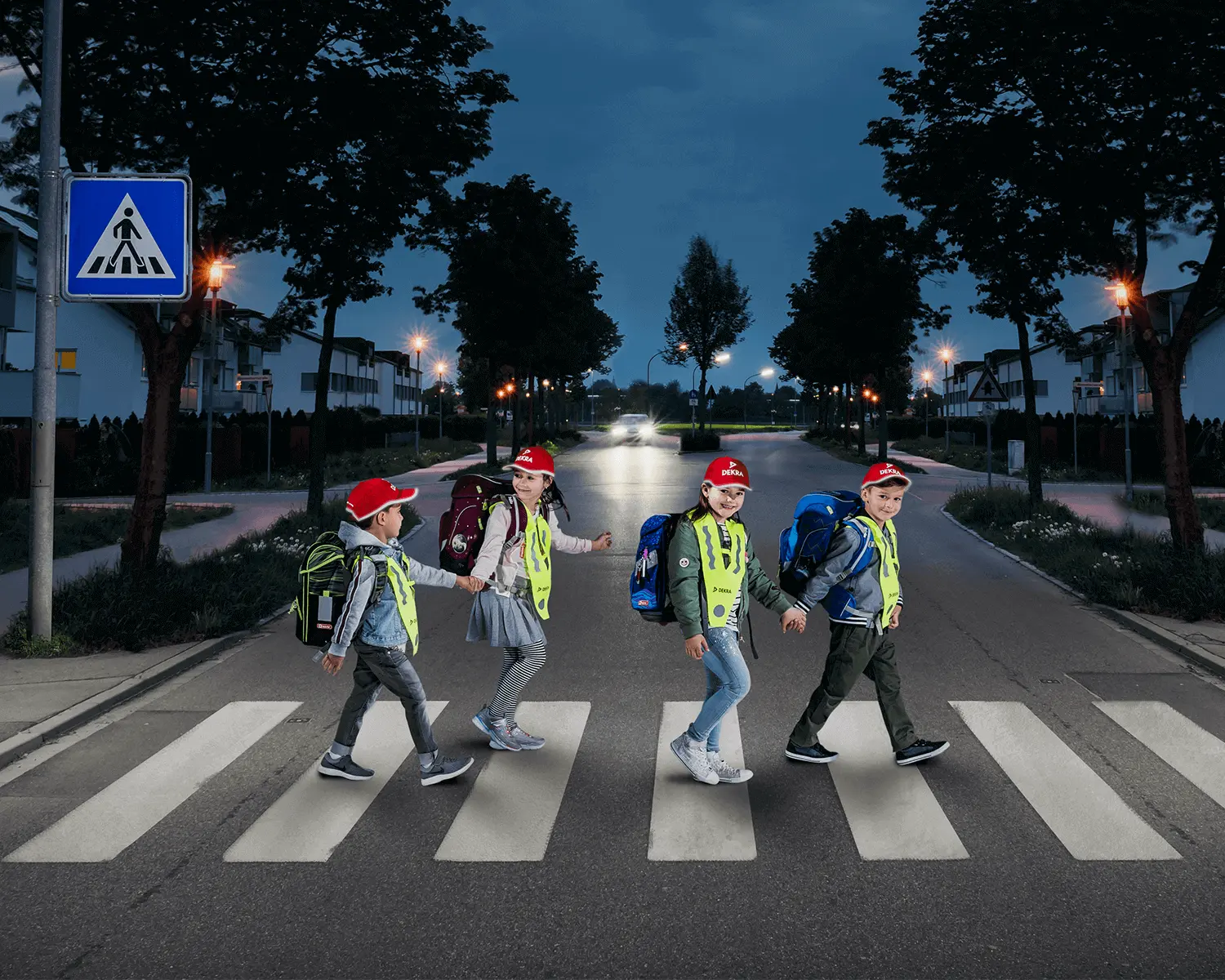 Kinder mit Kinderkappen laufen über einen Zebrastreifen 