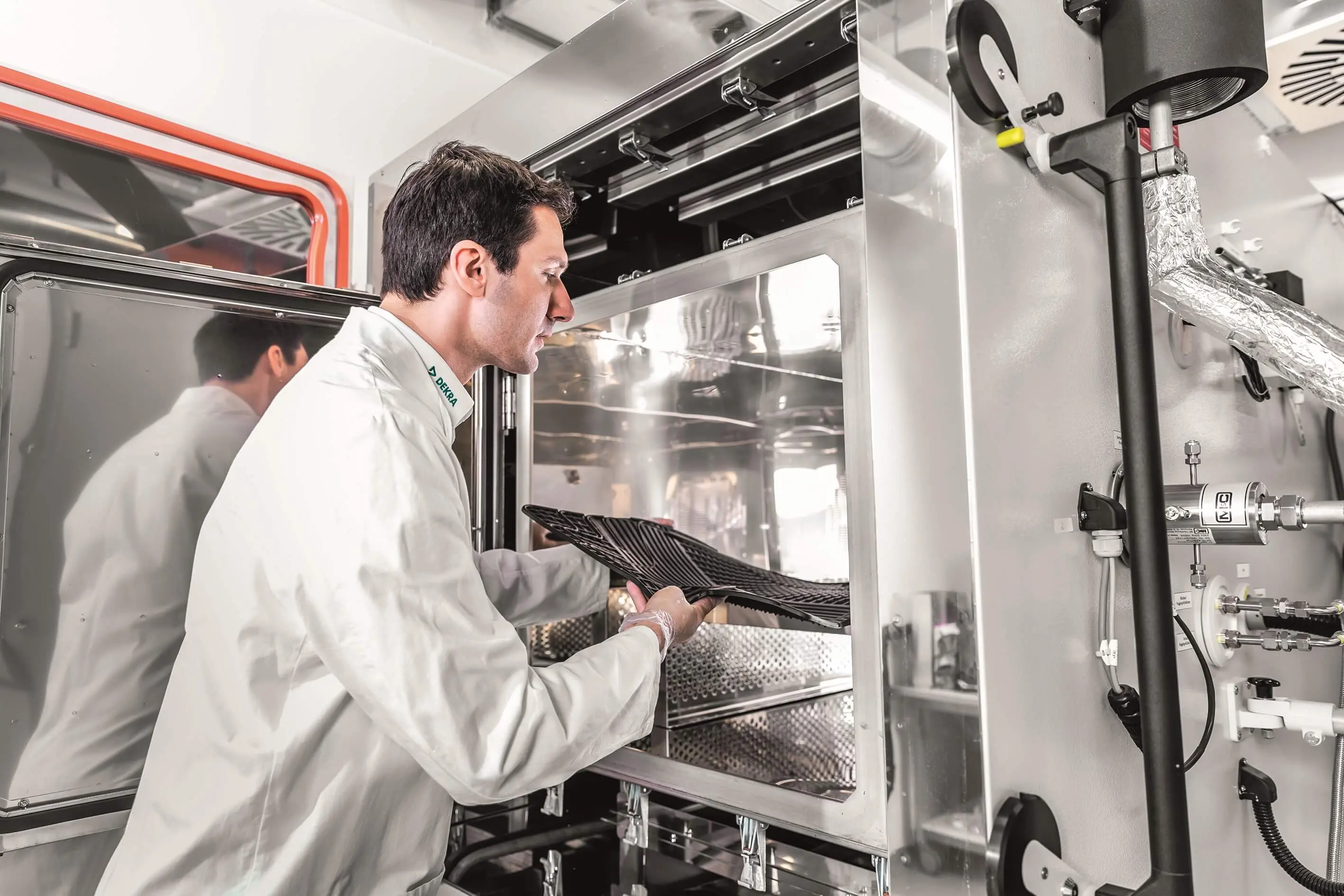 DEKRA Experte vor geöffneter Prüfkammer