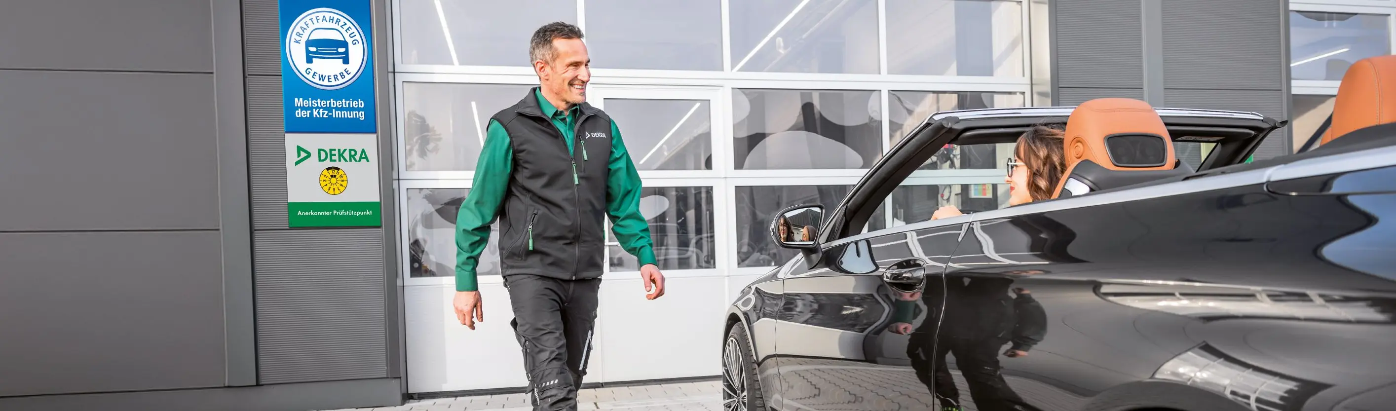 DEKRA Experte steht neben Cabrio mit Frau am Steuer