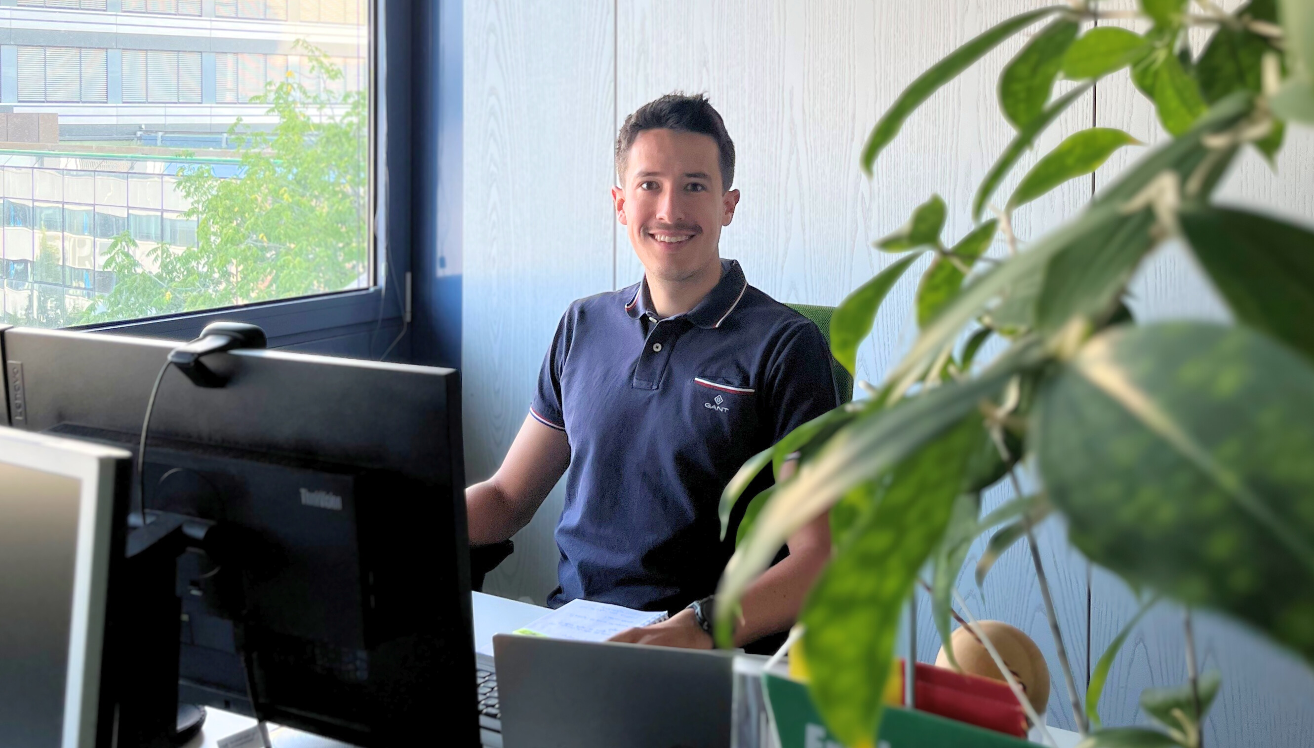 Moritz Stocker, Referent für Nachhaltigkeitsmanagement bei DEKRA, am Schreibtisch Moritz Stocker, Referent für Nachhaltigkeitsmanagement bei DEKRA, am Schreibtisch