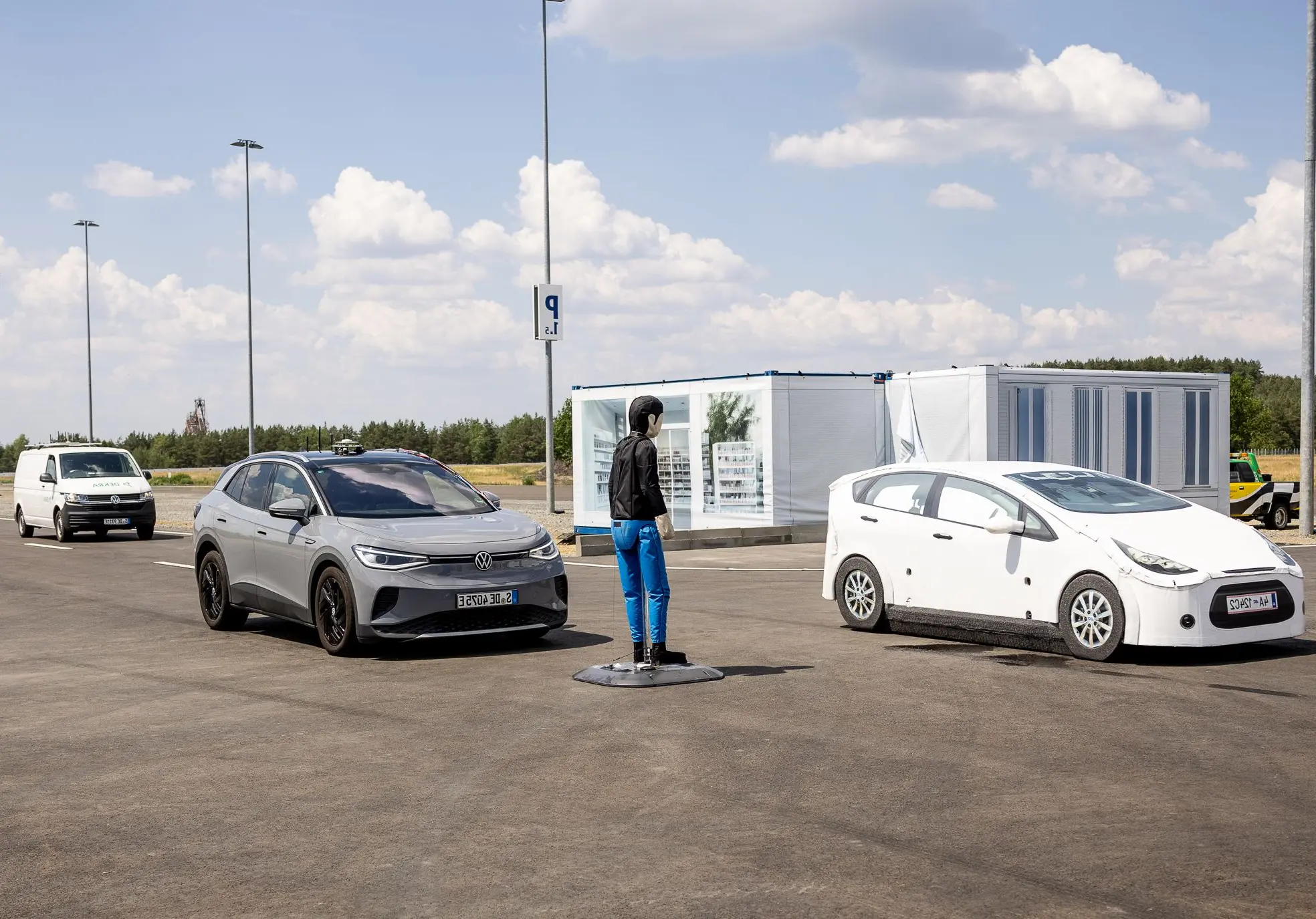 Zwei Testfahrzeuge und ein Test-Dummy auf einer Teststrecke Zwei Testfahrzeuge und ein Test-Dummy auf einer Teststrecke