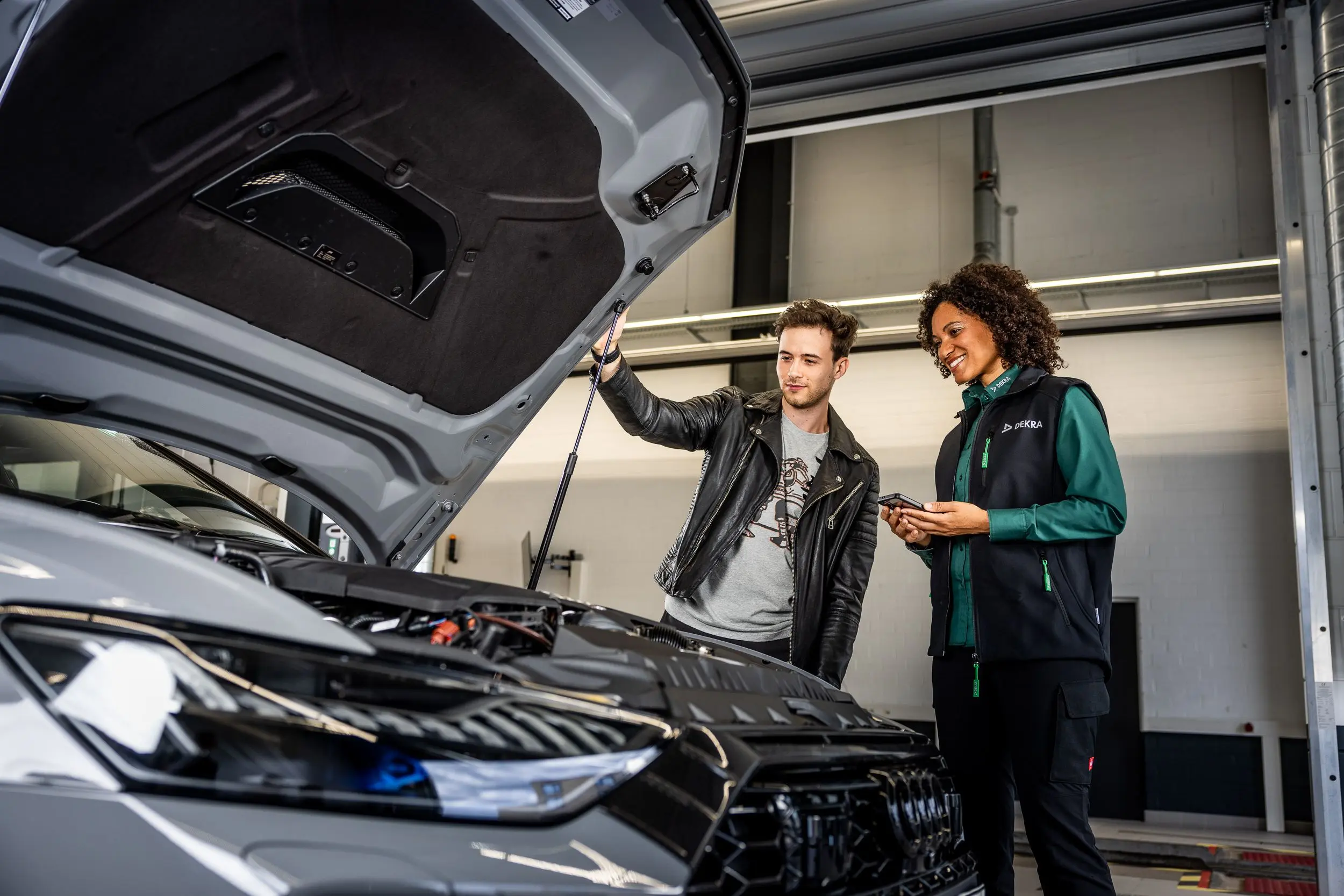 DEKRA Sachverständige und Kunde bei der Fahrzeugprüfung
