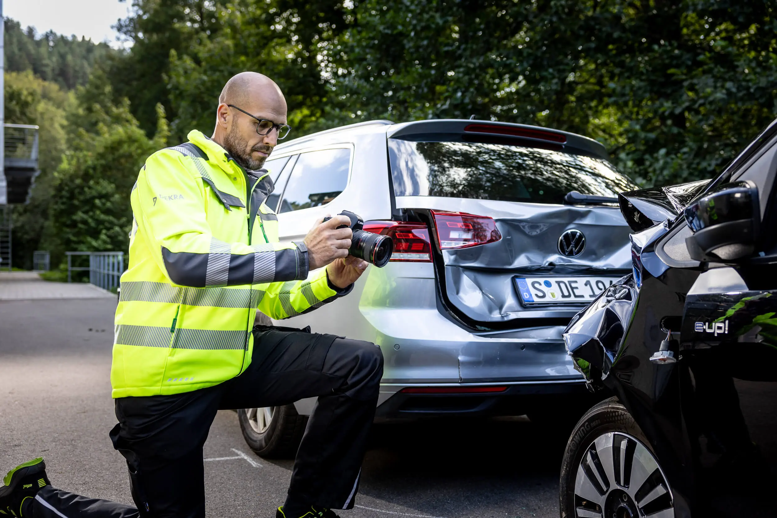 DEKRA Kfz-Sachverständiger bei Unfallanalyse: fotografiert Auffahrunfall zweier Autos mit einer Kamera
