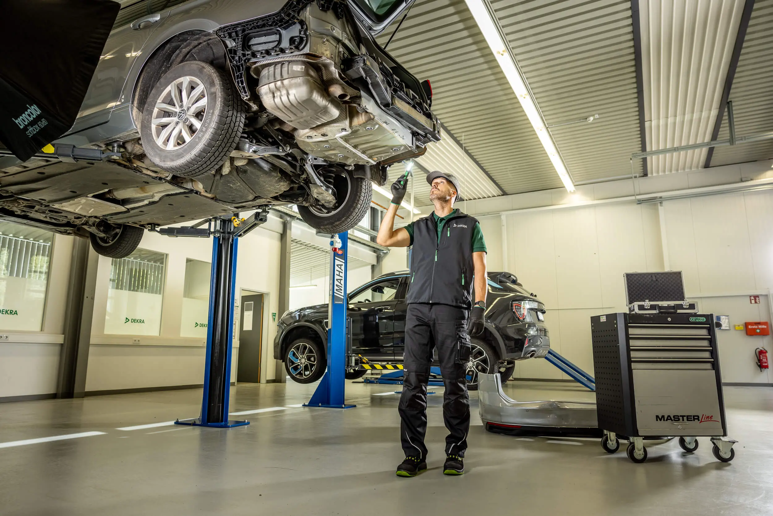 DEKRA Prüfingenieur unter Hebebühne