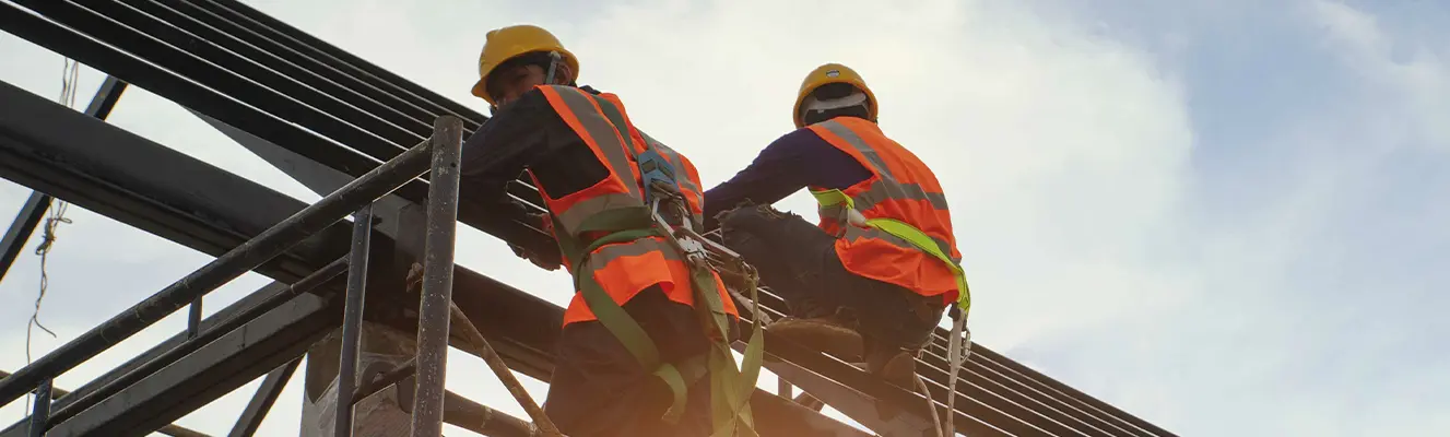 Zwei Personen mit Schutzkleidung auf einem Gerüst Zwei Personen mit Schutzkleidung auf einem Gerüst