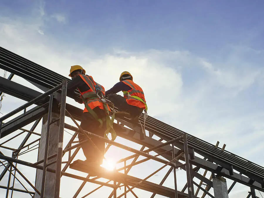 Zwei Arbeiter mit Schutzkleidung auf einem Gerüst