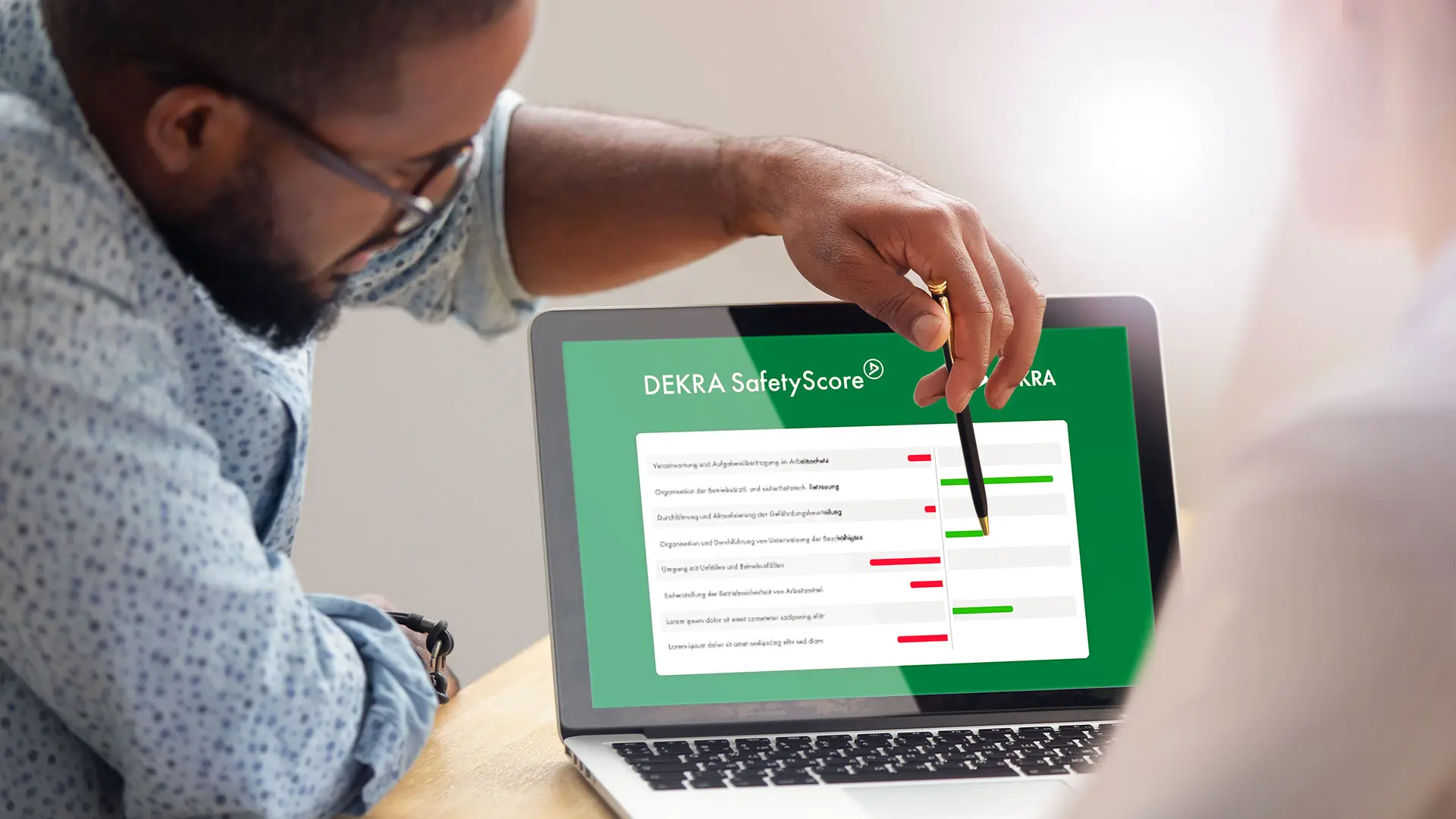 DEKRA Experte zeigt Kunden Ergebnisse auf einem Laptop