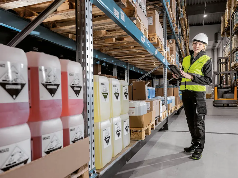 Frau mit Schuzuausrüstung in Lagerhalle