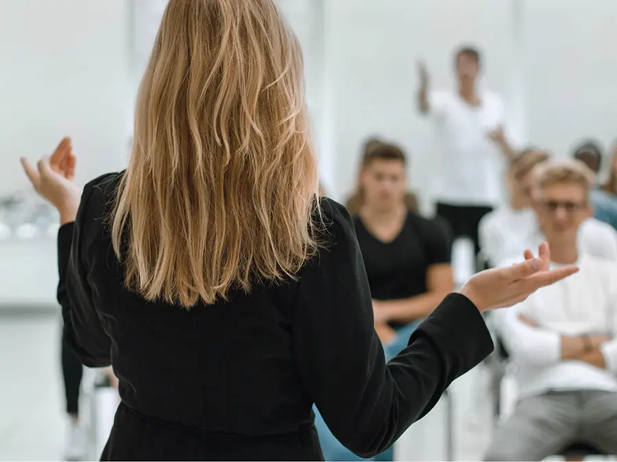 Eine Frau referiert vor einer Gruppe