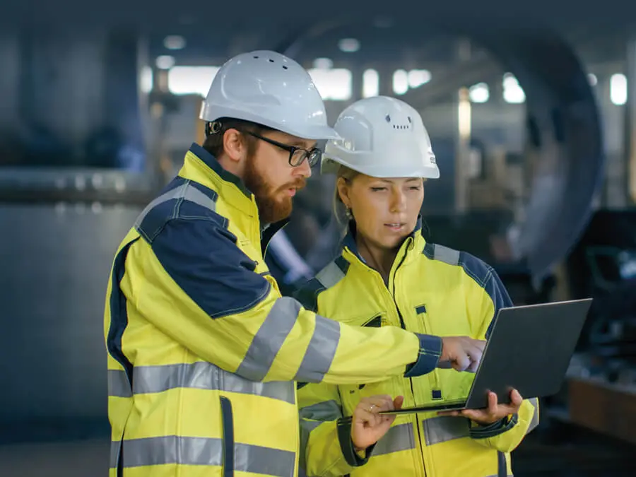 Frau und Mann mit Schutzkleidung bei der Arbeit