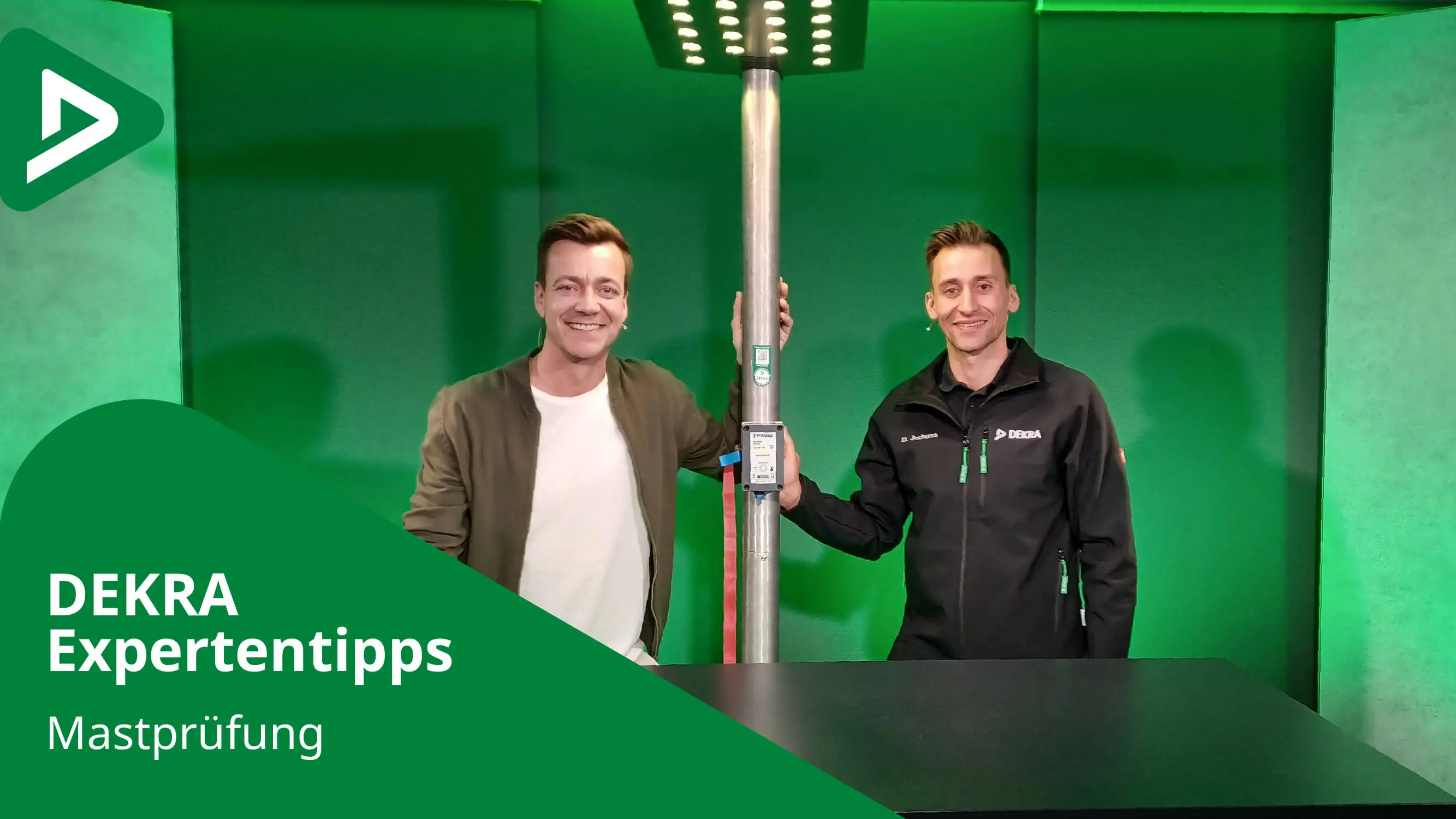 DEKRA Experte mit Moderator Wobbe neben einem Mast