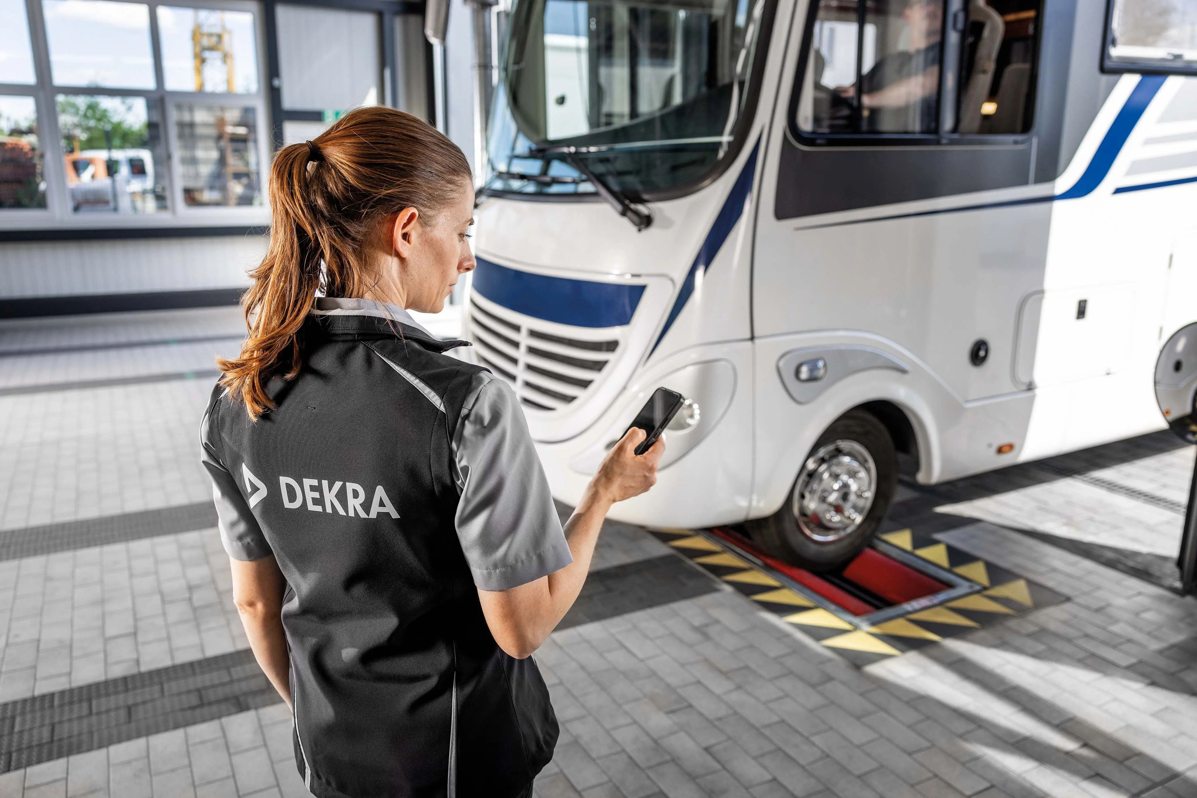 Wohnmobil und Prüferin bei der Hauptuntersuchung