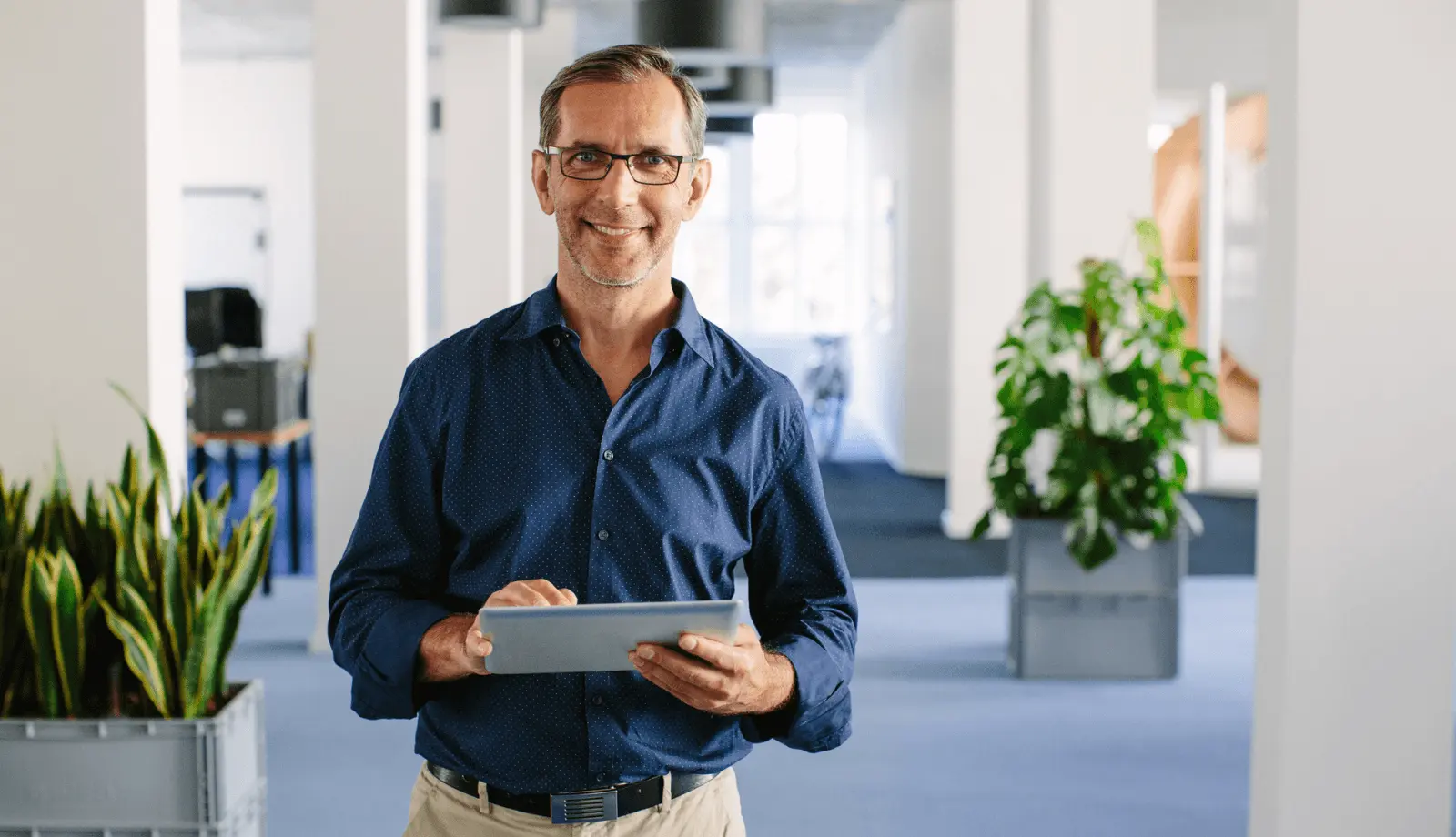 man smiling at the camera, holding a tablet man smiling at the camera, holding a tablet