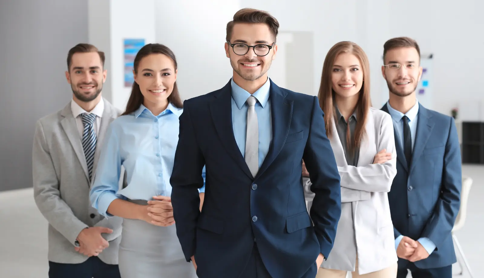 Five professionals in business attire smiling directly at the camera. Five professionals in business attire smiling directly at the camera.