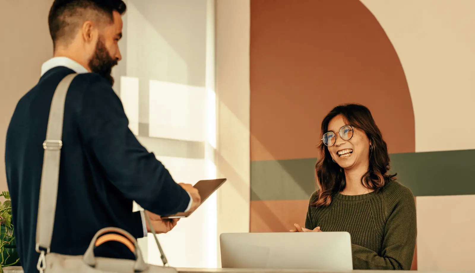 A man purchasing a product with assistance from a female salesperson in a store