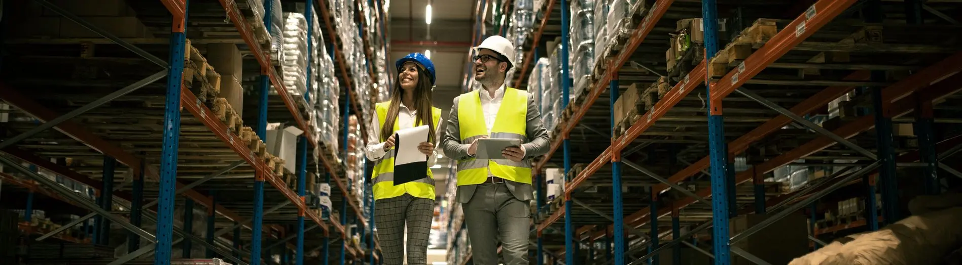 Two warehouse employees walking in a warehouse