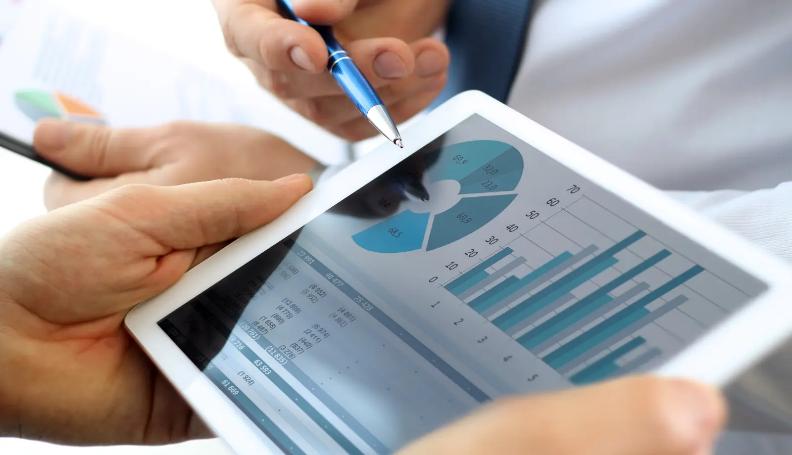 A tablet showing a dashboard with charts and business performance metrics. A tablet showing a dashboard with charts and business performance metrics.