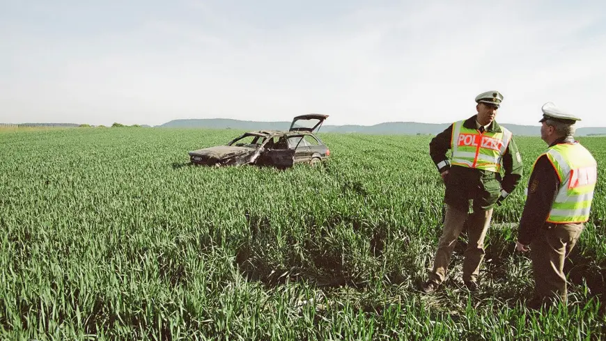 Endstellung des Unfallwagens im Feld, Polizisten