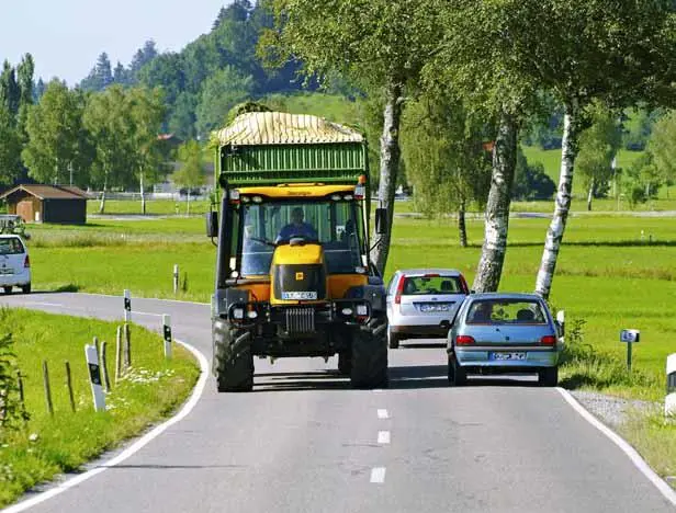 Großer Traktor ragt über seine Fahrbahn