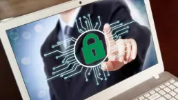 Zielona kłódka na ekranie laptopa, symbolizująca cyberbezpieczeństwo