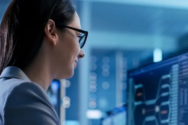 Kobieta wpatrująca się w ekran komputera, symbolizująca pracę Audytora Wiodącego ISO 27001 Kobieta wpatrująca się w ekran komputera, symbolizująca pracę Audytora Wiodącego ISO 27001