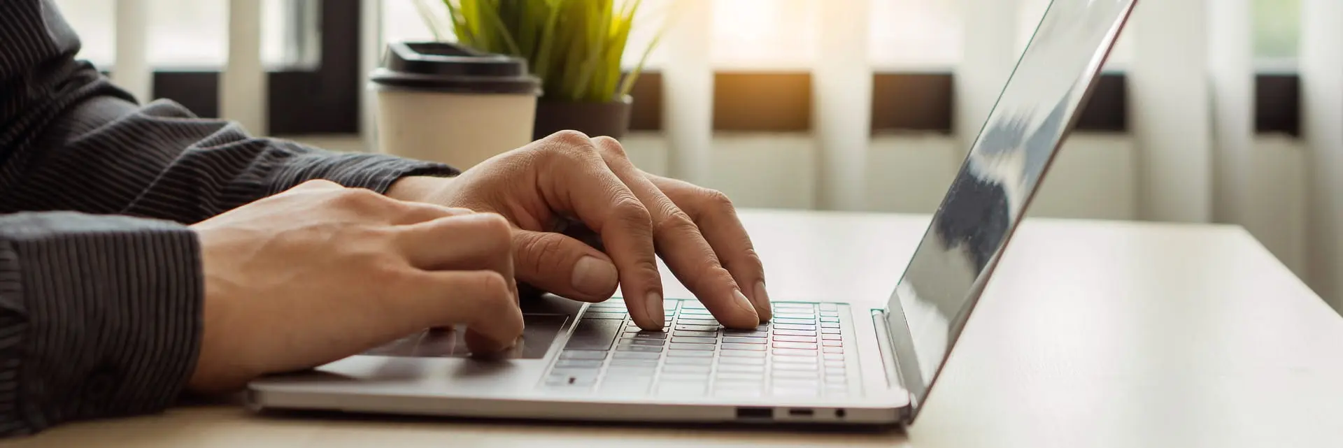 Dlonie mężczyzny piszącego na klawiaturze, symbolizujące audyt ochrony danych osobowych