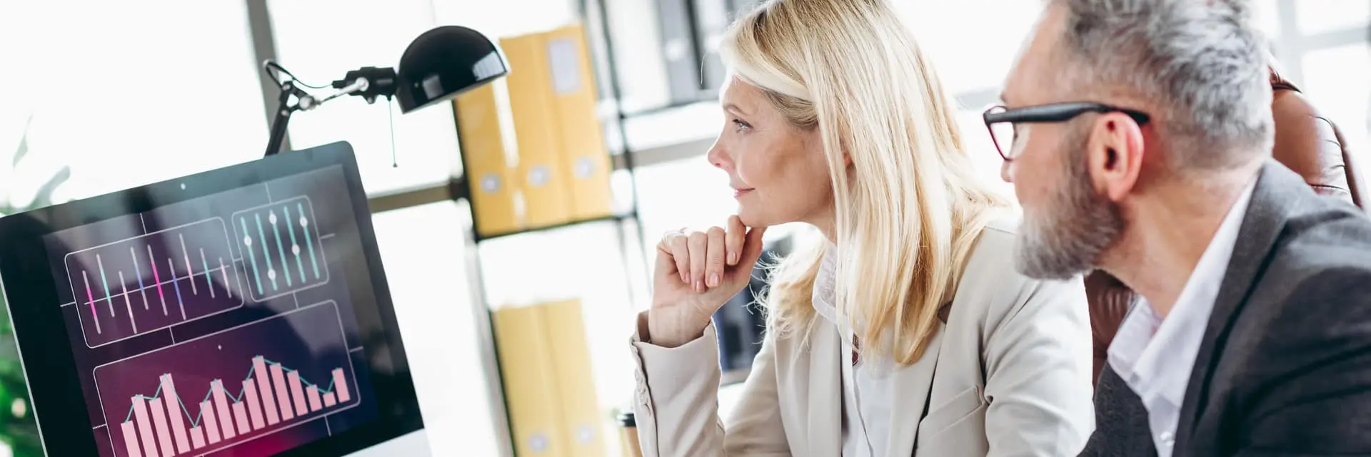 Zespół specjalistów analizujący wykresy i dane na ekranie komputera