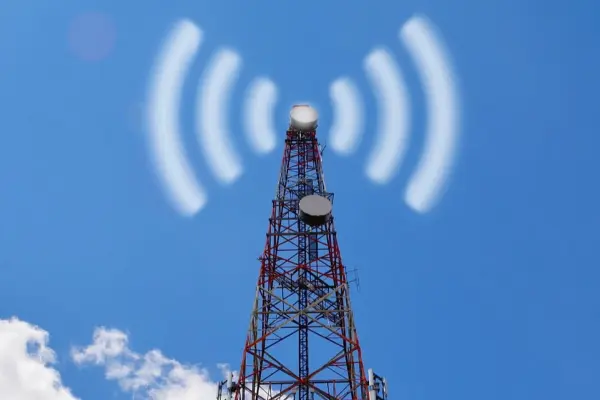 Wieża nadawcza z sygnałem radiowym na tle błękitnego nieba Wieża nadawcza z sygnałem radiowym na tle błękitnego nieba