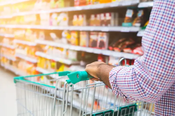 Mężczyzna prowadzący wózek zakupowy, robiący zakupy w supermarkecie