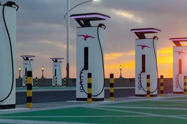 Stacja ładowania samochodów elektrycznych na tle zachodzącego słońca Stacja ładowania samochodów elektrycznych na tle zachodzącego słońca