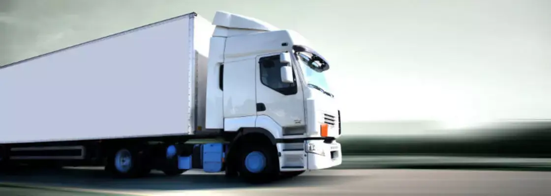 Biała ciężarówka jadąca po drodze. Certyfikacja i audyt dla branży transportowej i logistycznej. Biała ciężarówka jadąca po drodze. Certyfikacja i audyt dla branży transportowej i logistycznej.