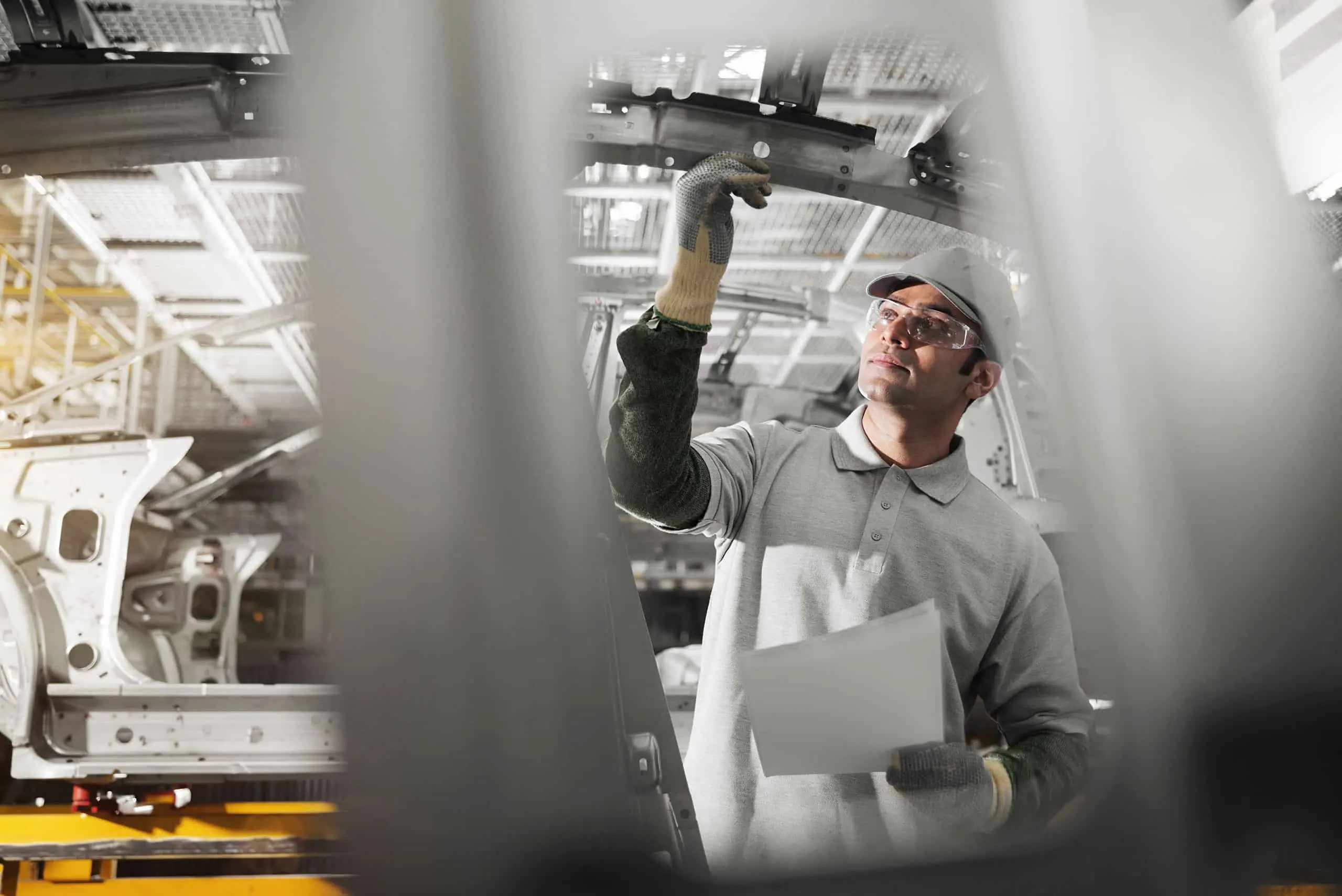 Pracownik inspekcji linii produkcyjnej, przedstawiający certyfikację IATF 16949 w branży motoryzacyjnej