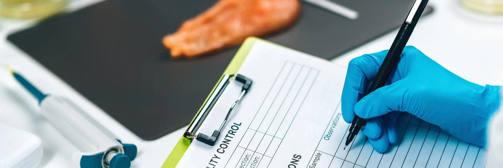 Inspektor w rękawiczkach wypełniający formularz kontroli jakości produktu spożywczego 