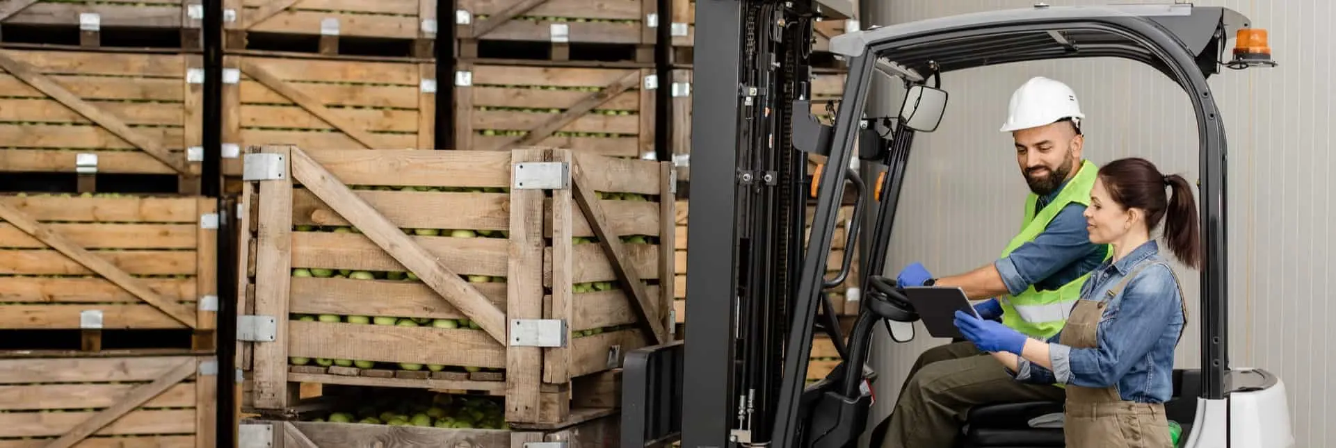 Pracownicy logistyki kontrolujący przesyłkę świeżych owoców przy załadunku w magazynie, co symbolizuje certyfikację IFS Progress Logistics