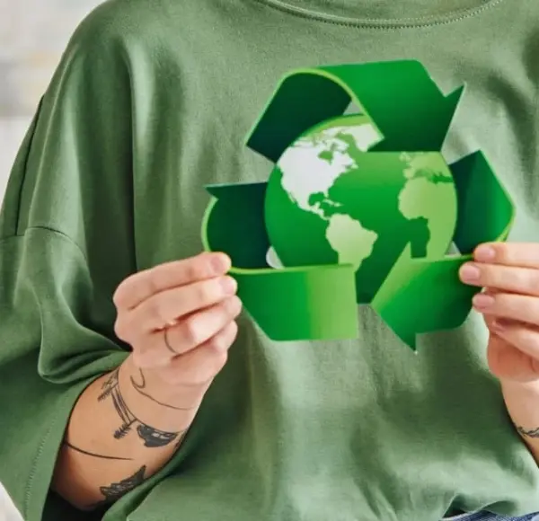Kobieta trzymająca w dłoniach zieloną kulę ziemską, otoczoną znakiem recyklingu, co symbolizuje certyfikację ISO 14001 Kobieta trzymająca w dłoniach zieloną kulę ziemską, otoczoną znakiem recyklingu, co symbolizuje certyfikację ISO 14001