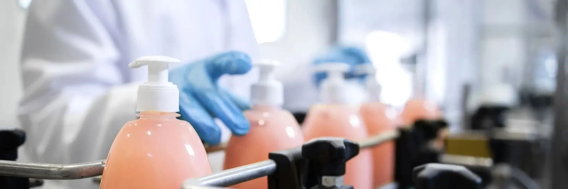 Pracownik, pracujący przy produkcji kosmetyków na linii produkcyjnej, symbolizuje certyfikację ISO 22716 Pracownik, pracujący przy produkcji kosmetyków na linii produkcyjnej, symbolizuje certyfikację ISO 22716