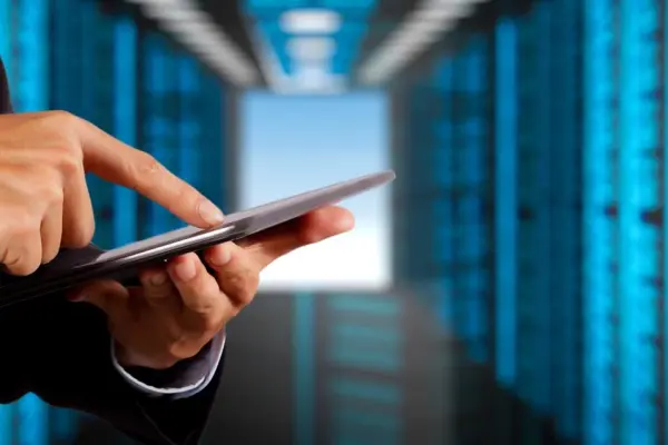 Pracownik używający tableta w serwerowni IT, symbolizujący certyfikację ISO 27001 Pracownik używający tableta w serwerowni IT, symbolizujący certyfikację ISO 27001